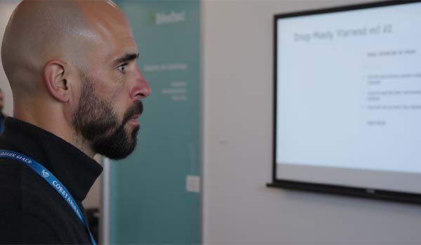 Alvaro Torres reviewing a creative brief on a whiteboard with post-its